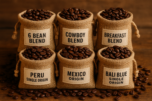 six small burlap bags containing fresh roasted coffee and labeled 6 Bean Blend, Cowboy Blend, Breakfast Blend, Peru Single Origin, Mexico Single Origin, and Bali Blue Single Origin.